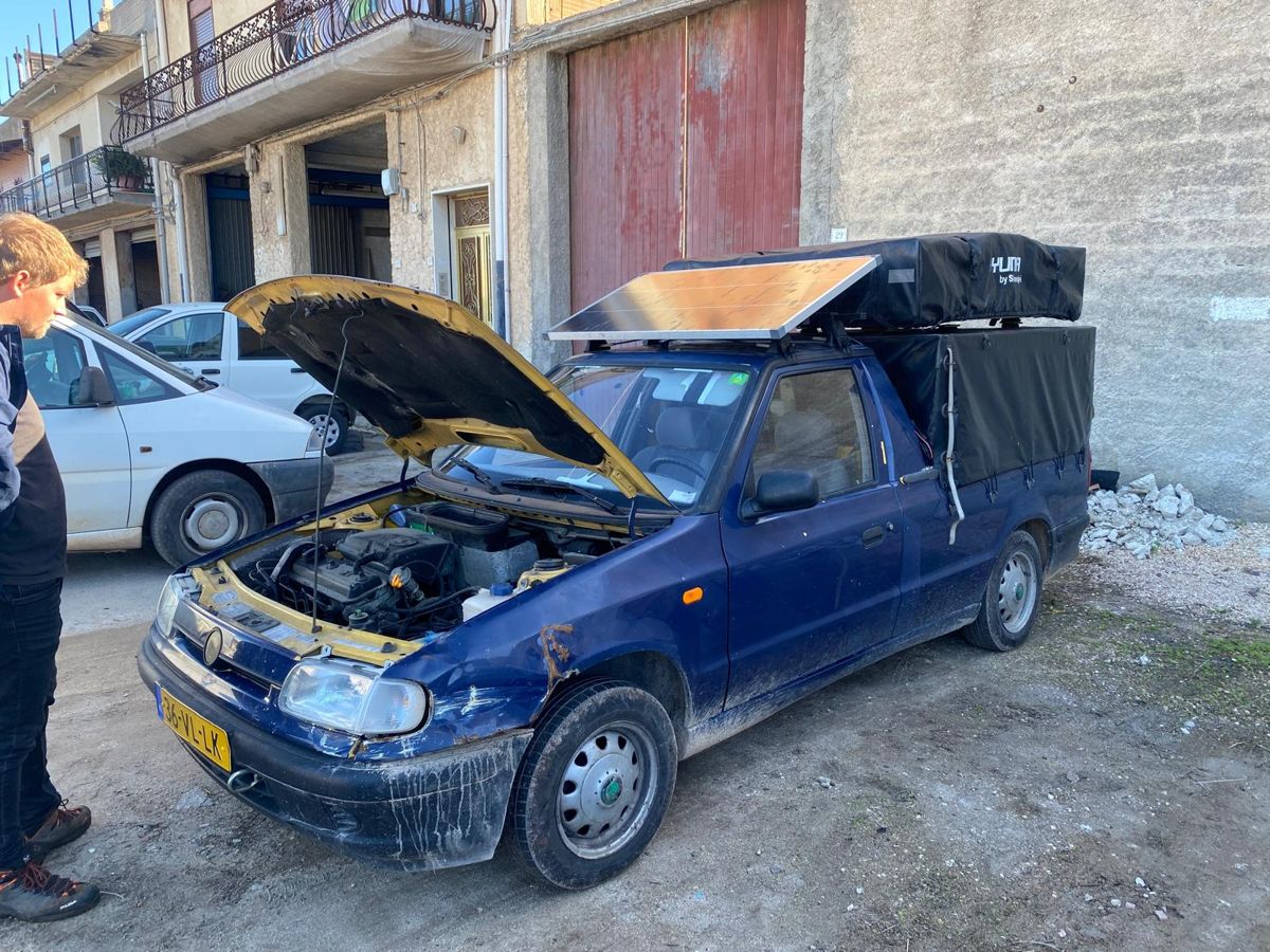 Ons blauwe Skoda-autootje met de motorkap open, ergens op Sicilië